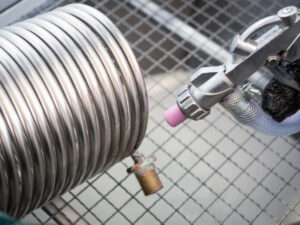 Sandblasting of a heat exchanger inside a special sandblasting cabin.